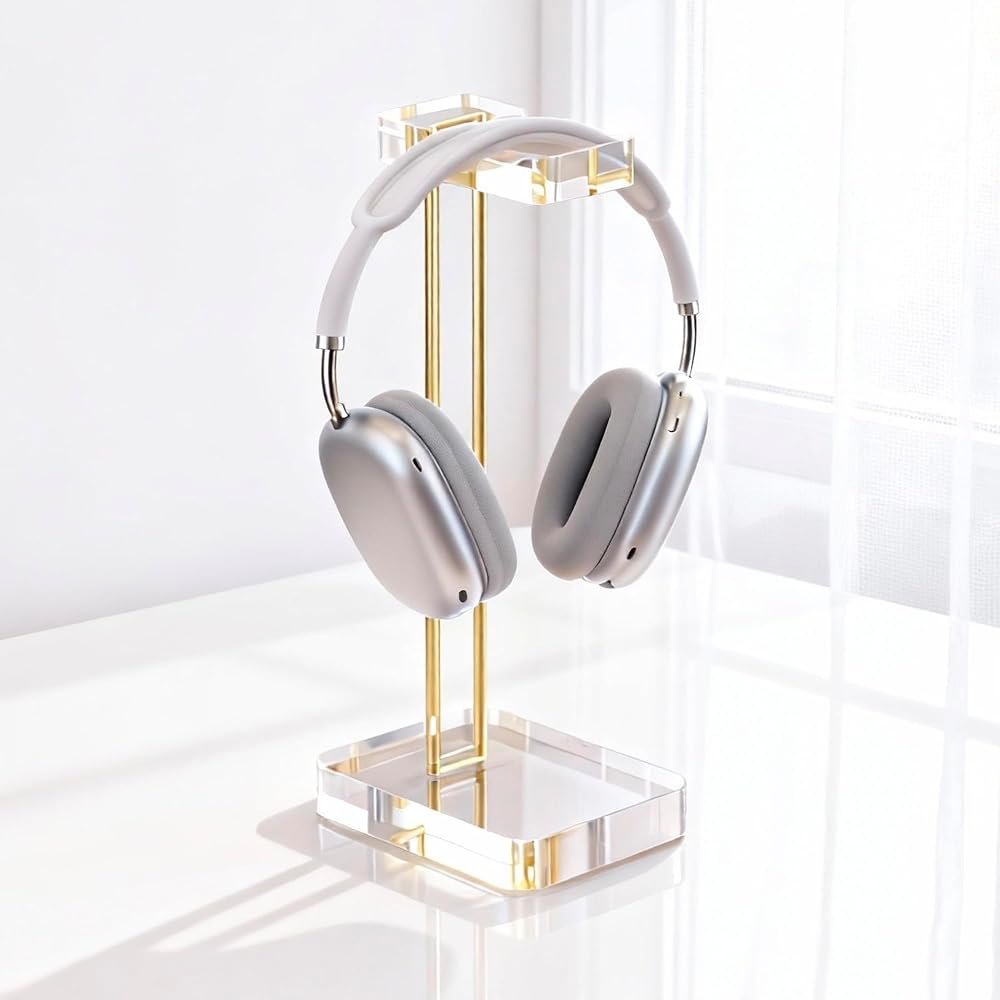 Crystal acrylic headphone stand with gold base on a white and gold office desk